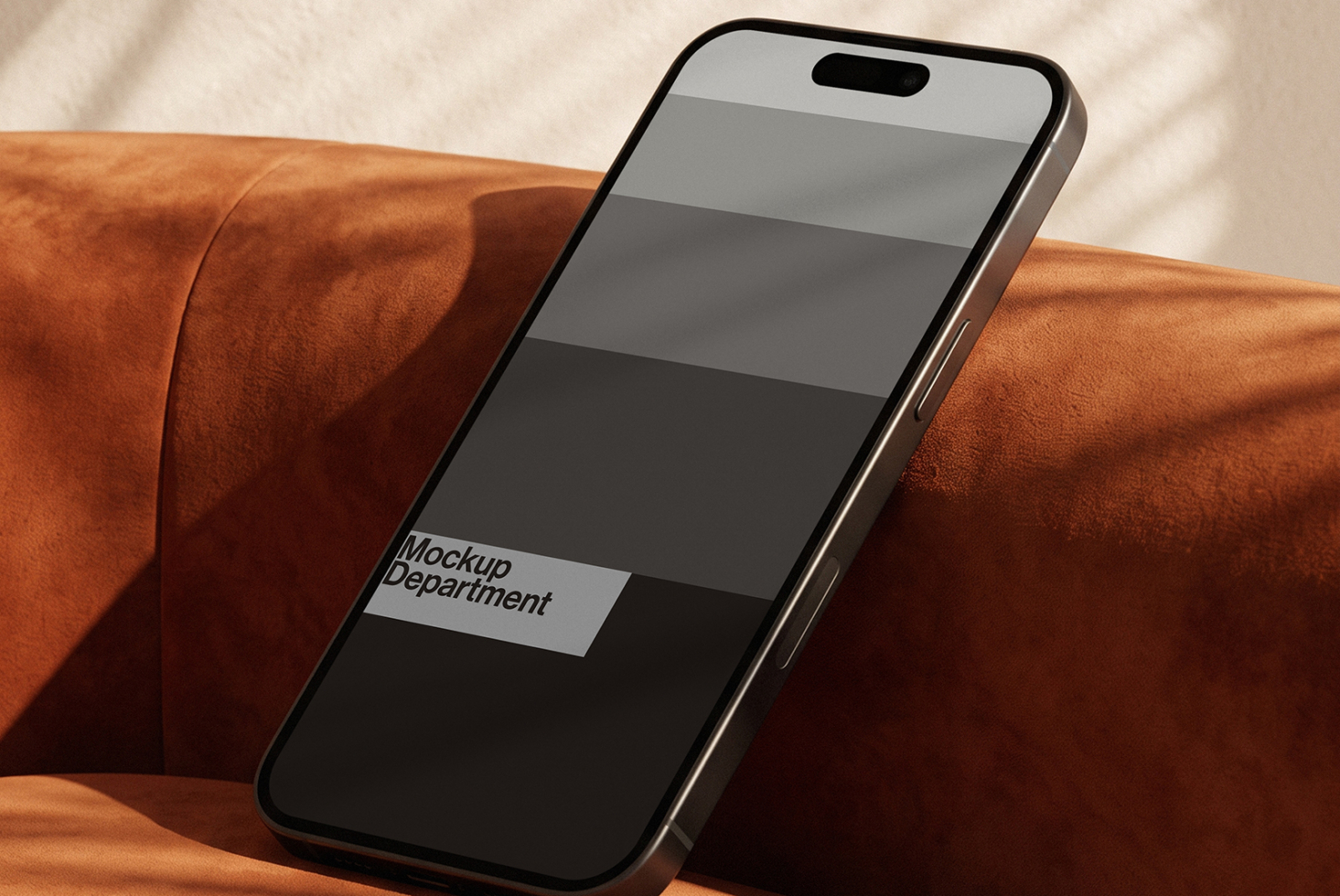 iPhone on rust leather couch with sunlight casting shadows across screen