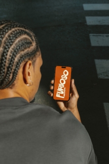 Person holding phone with orange screen showing Furlogo mockup text