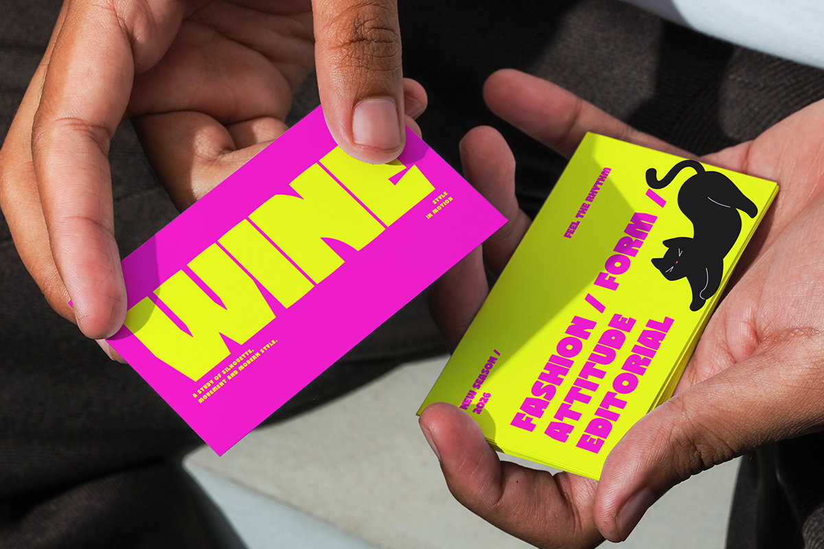 Two hands holding vibrant neon business cards with bold magenta, yellow, lime colorways plus black dog illustration