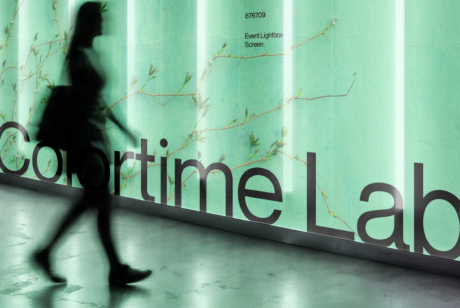 Blurred person walking past mint green lightbox with dried branches, text overlay mockup