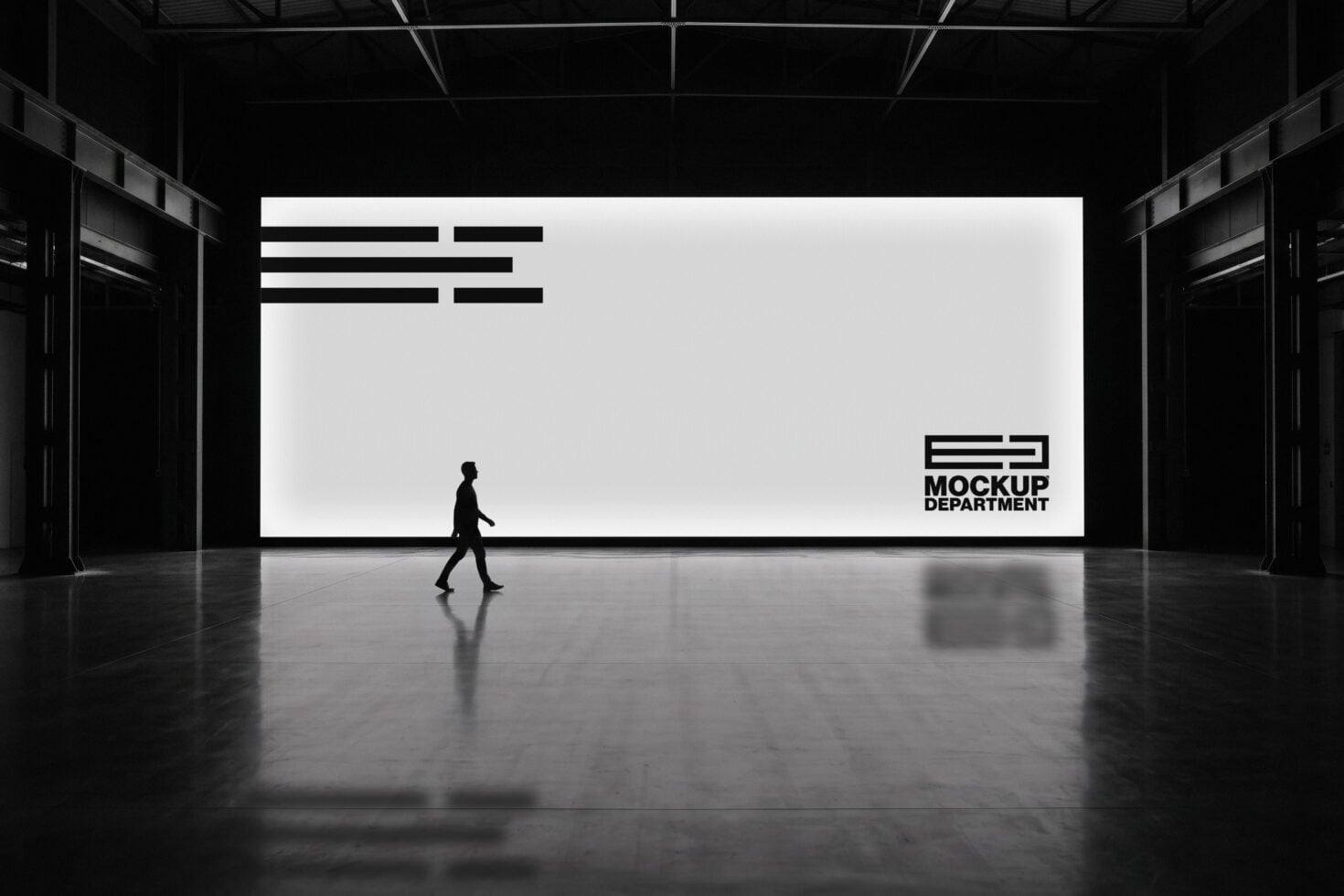 Silhouette of person walking past massive warehouse billboard with minimalist logo design