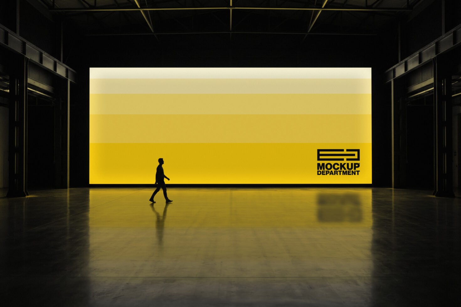 Large yellow billboard mockup in warehouse space with silhouette figure walking past