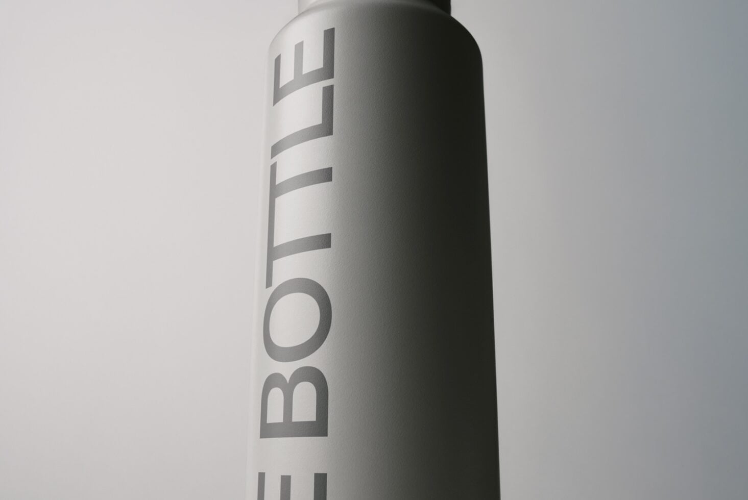 Spray can mockup with vertical text wrap, metallic finish on neutral background