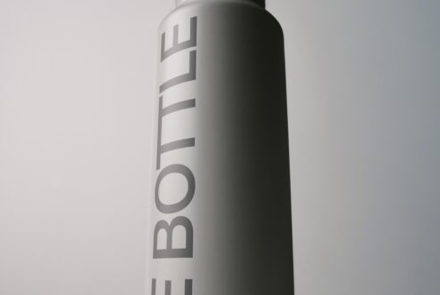 Spray can mockup with vertical text wrap, metallic finish on neutral background