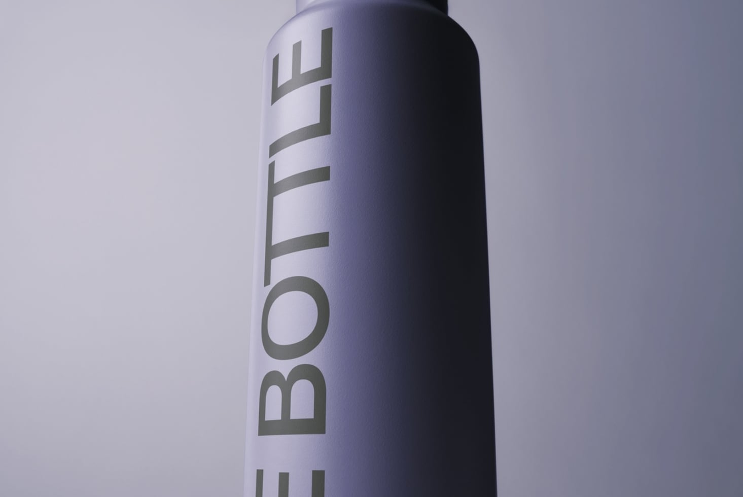 Tall spray bottle mockup with gradient fade from white to dark purple, vertical text wrapping around cylinder