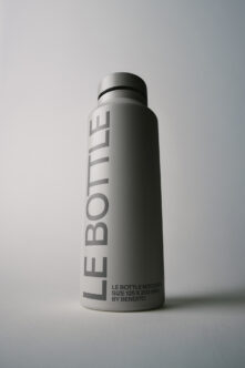 Sleek stainless steel bottle mockup with vertical branding, clean minimal aesthetic on white background