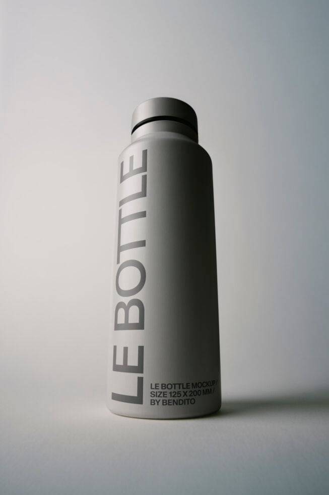 Sleek stainless steel bottle mockup with vertical branding, clean minimal aesthetic on white background