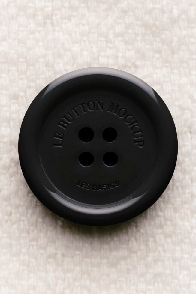 Black button mockup with embossed text on textured background