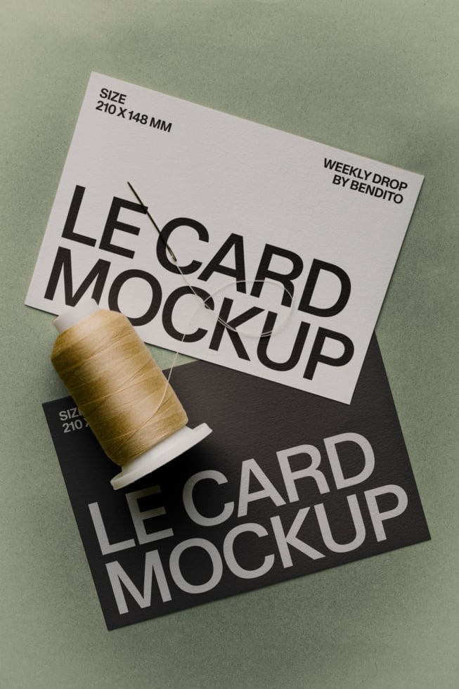 Two layered business cards with gold thread spool on sage green background