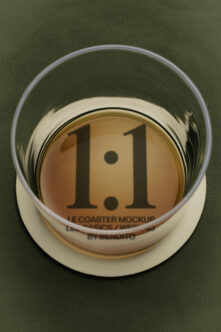 Glass coaster mockup with 1.1 version number on tan disk, cream ring, green background