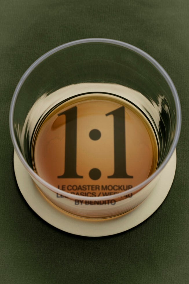 Glass coaster mockup with 1.1 version number on tan disk, cream ring, green background