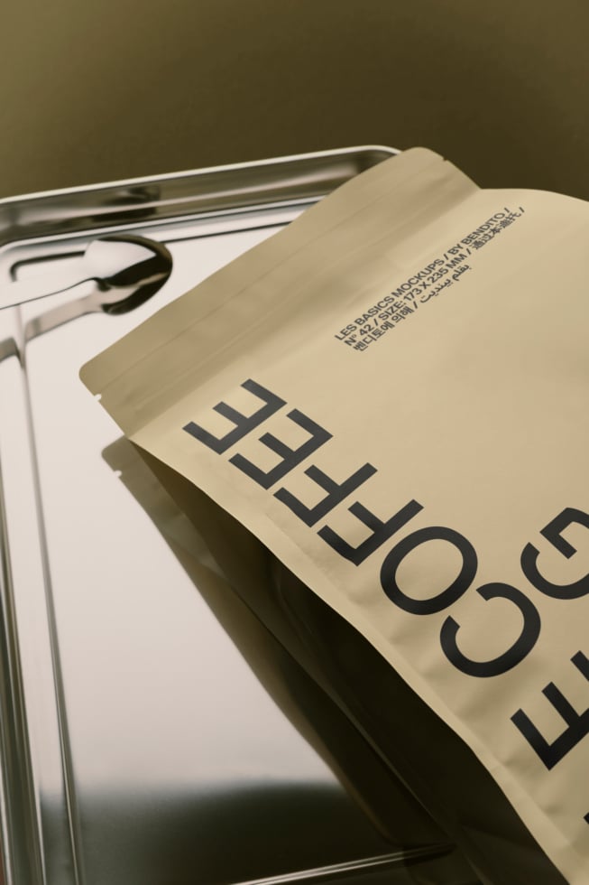 Cream colored magazine mockup draped over metal frame with glasses, earbuds visible on white page