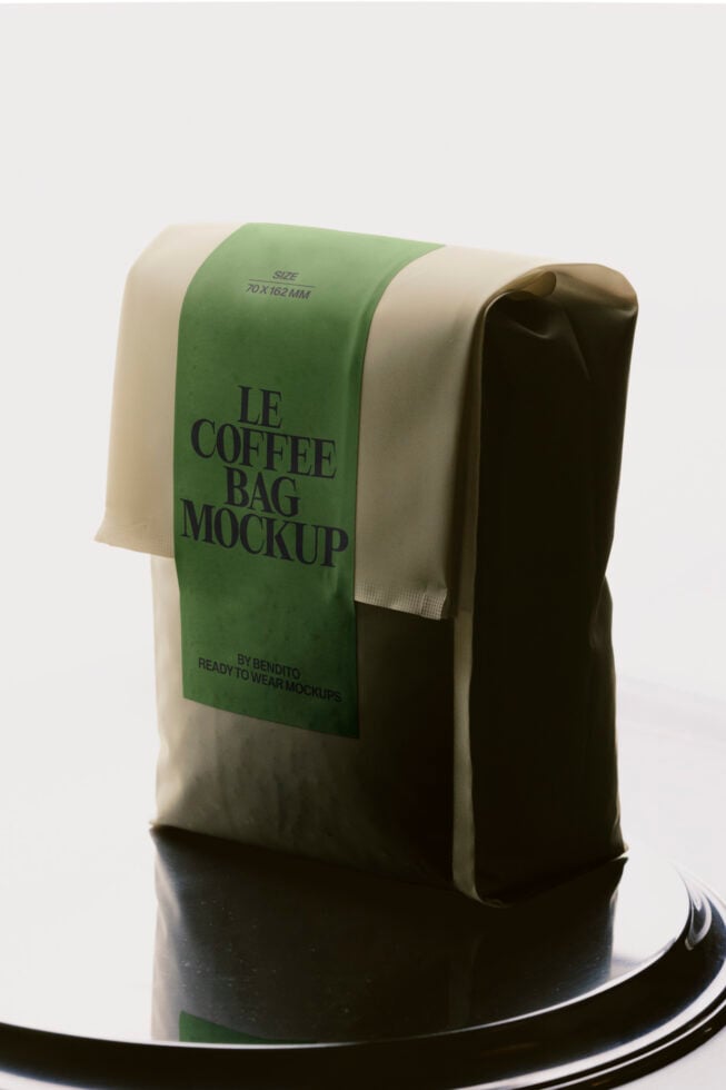 Coffee bag mockup with green label on cream pouch, sitting on black circular base