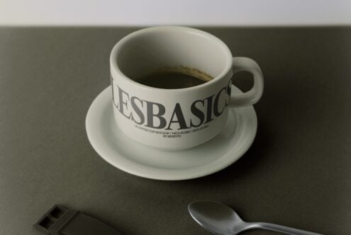Coffee cup with saucer mockup showing branded wrap text on ceramic cup with spoon