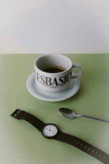 Coffee cup mockup with watch, spoon on sage green surface
