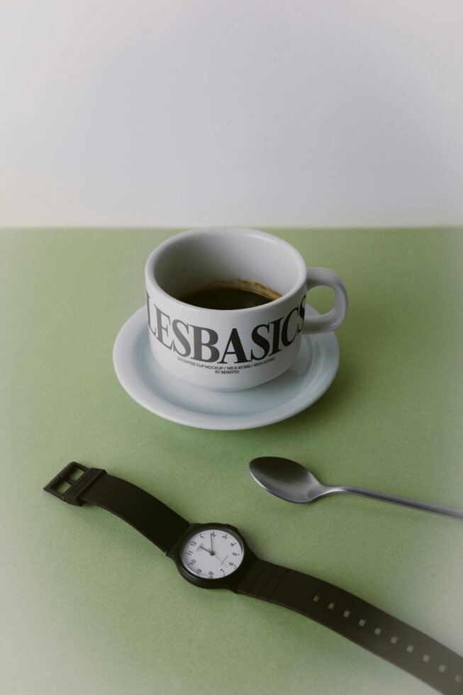 Coffee cup mockup with watch, spoon on sage green surface