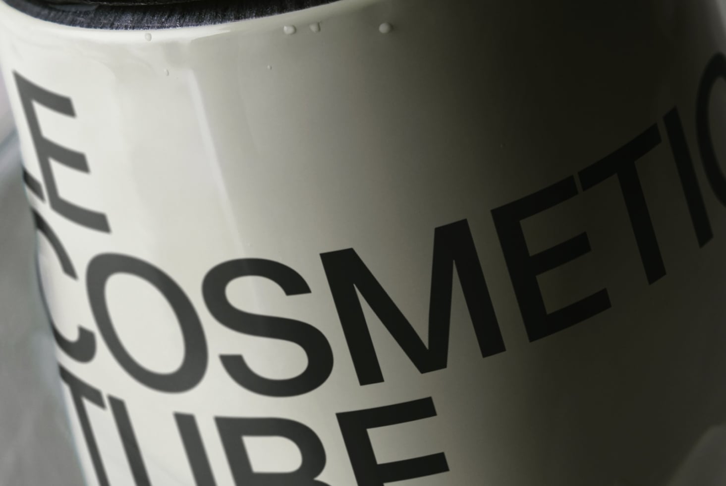 Close up of white mug with bold black typography, fabric handle visible at top