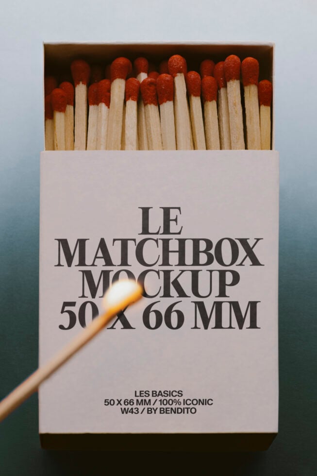 Matchbox mockup with red-tipped wooden matches spilling out, one lit match in foreground