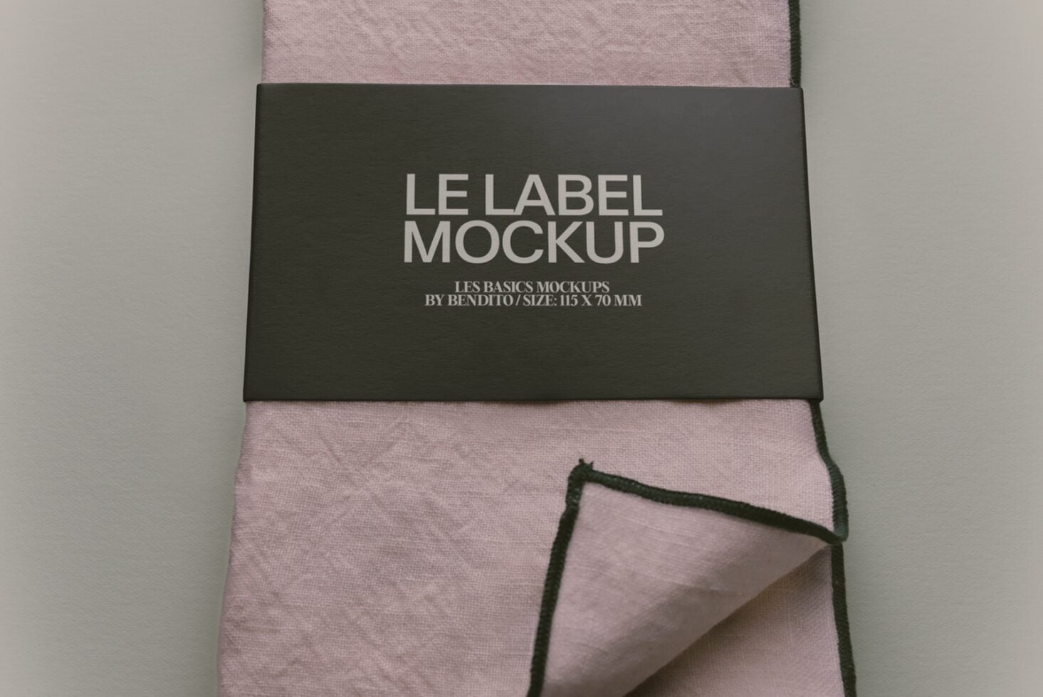 Label mockup on folded mauve fabric with charcoal band, 115 x 70mm size