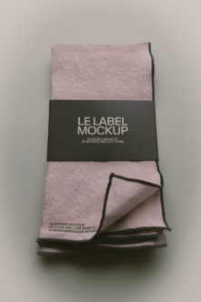 Folded mauve napkin with black label band showing mockup text, corner detail visible