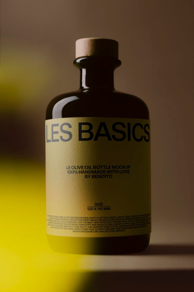 Dark glass olive oil bottle with cream label on yellow neon background