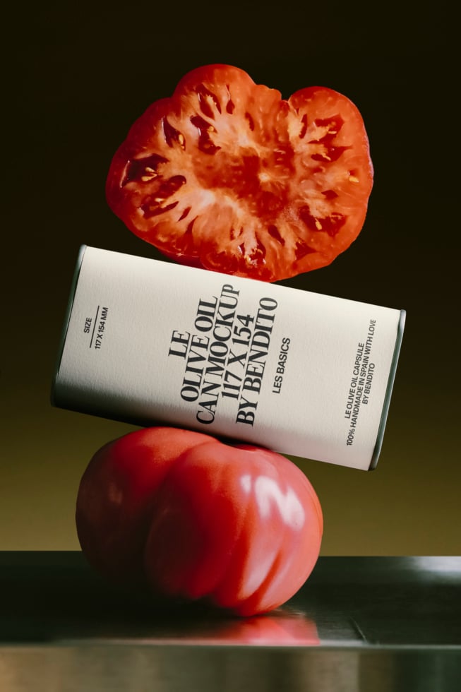 Skincare tube mockup balanced on fresh tomatoes with moody olive backdrop