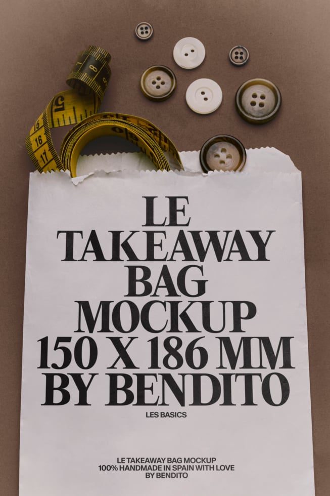Flat lay of white paper bag with measuring tape, buttons, styled on taupe background