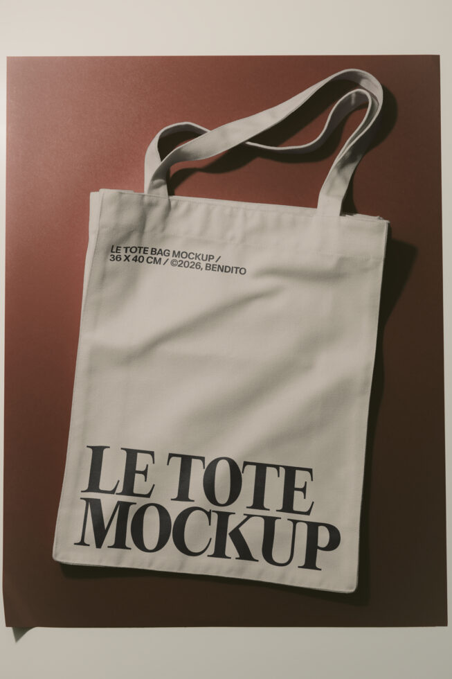 Cream canvas tote bag mockup with black serif typography on terracotta background