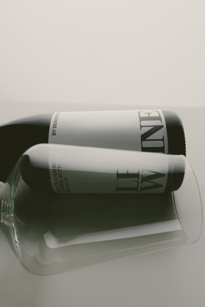 Two dark glass bottles with white labels stacked in clear cylinder packaging against neutral background