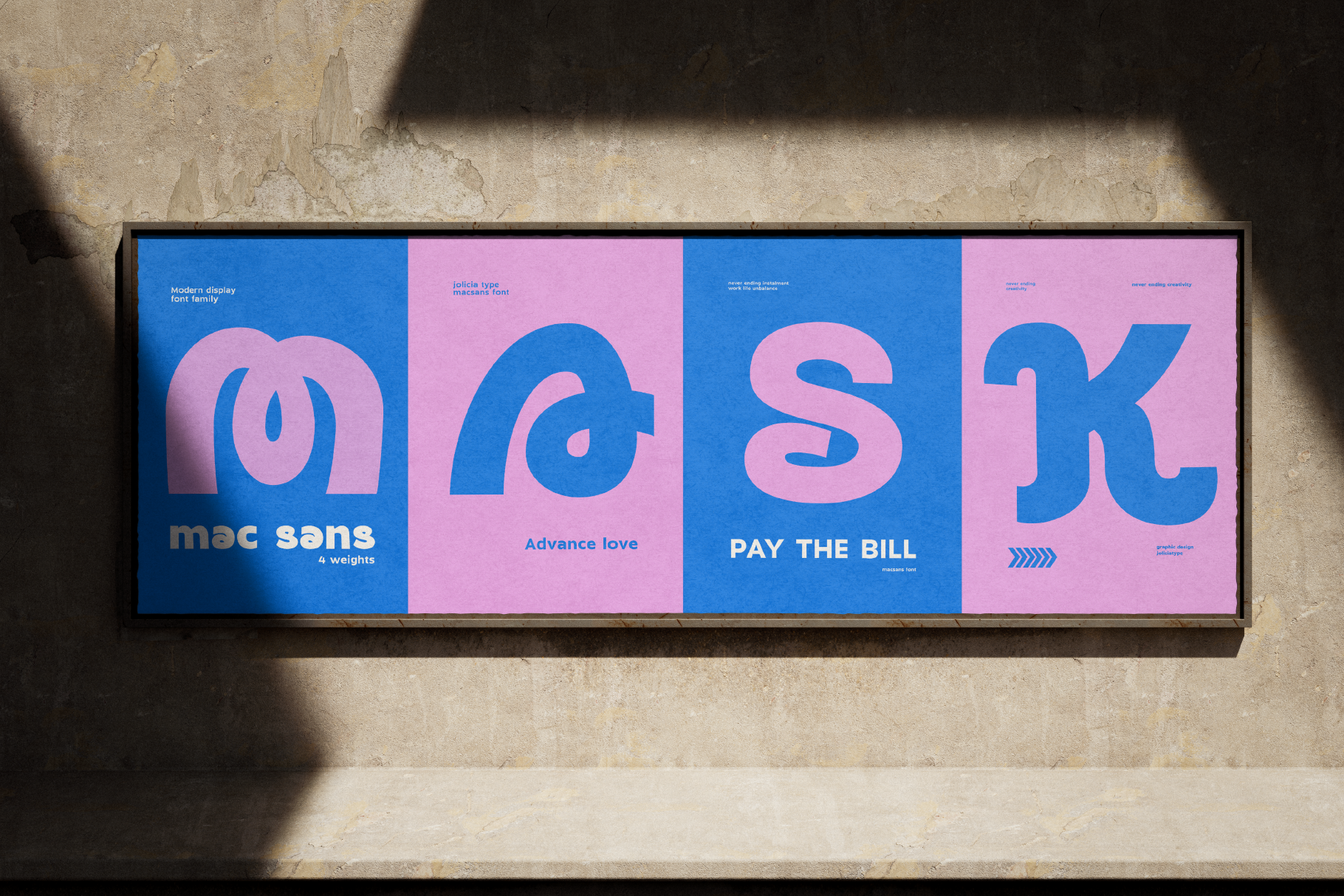 Framed display showing bold blue pink typography panels with Mac Sans font weights on concrete wall