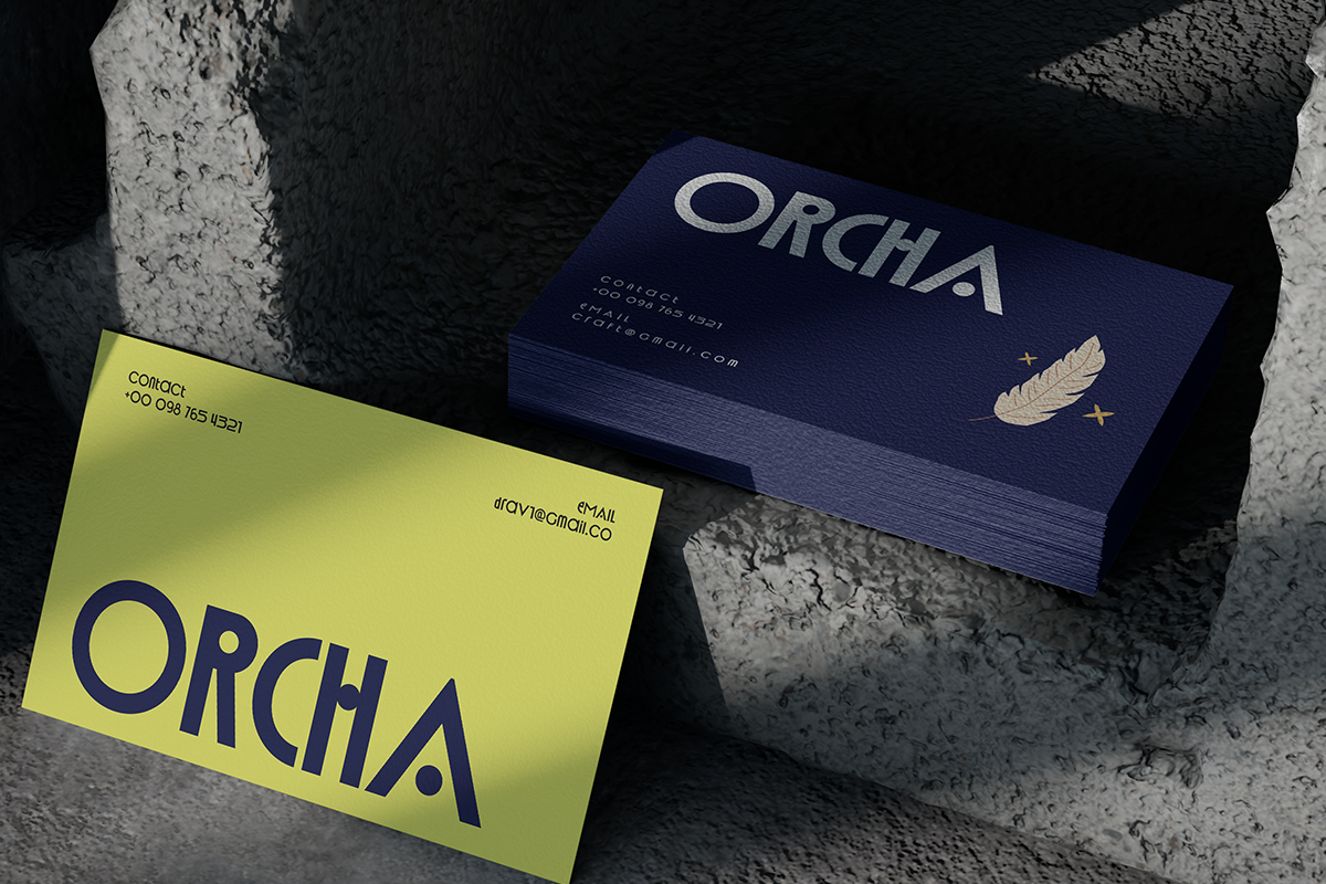 Orcha business cards mockup showing neon yellow plus navy designs with gold feather detail on concrete