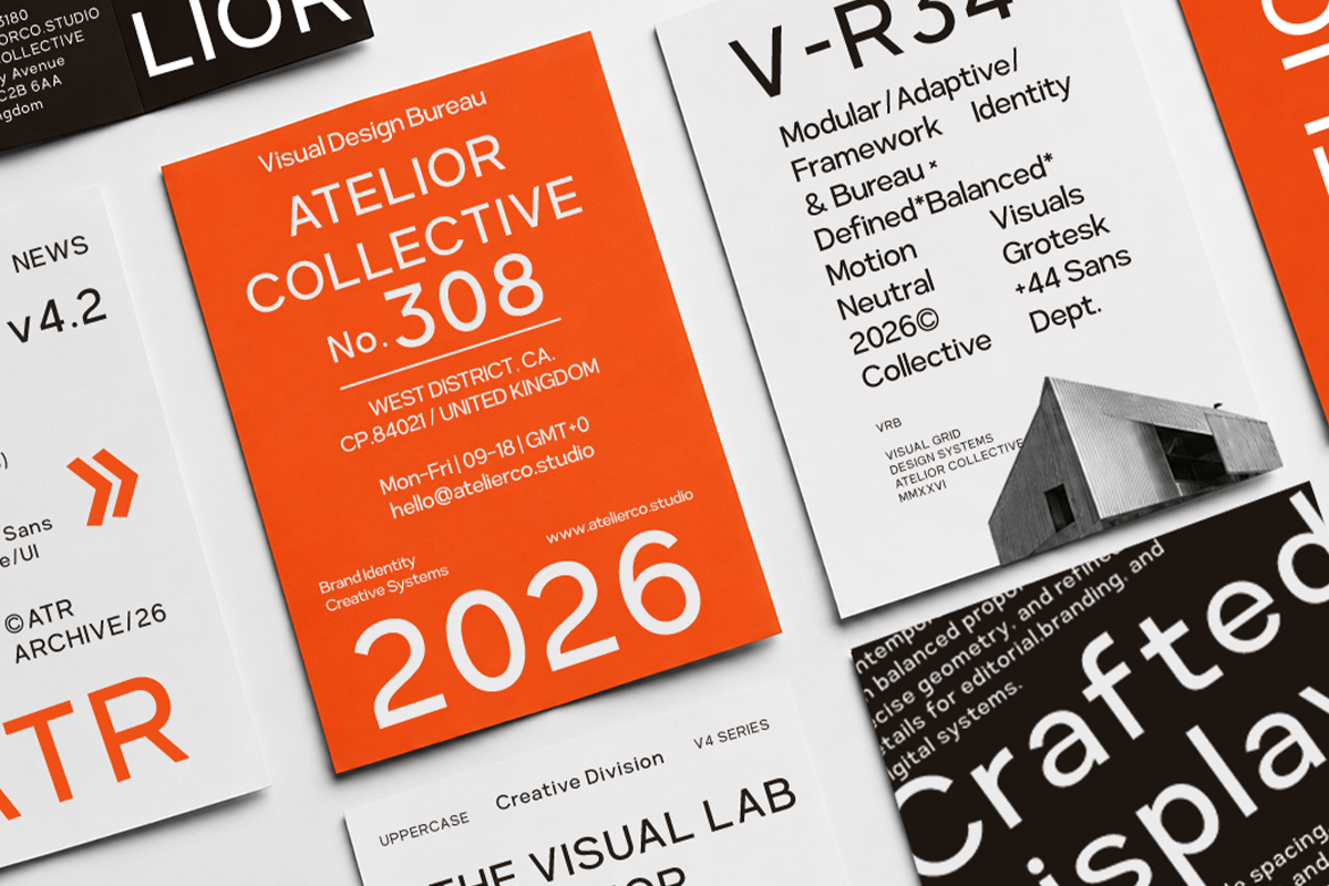 Flat lay of overlapping design system documents with bold orange card featuring Atelior Collective branding, typography specs, architectural photo, text layouts