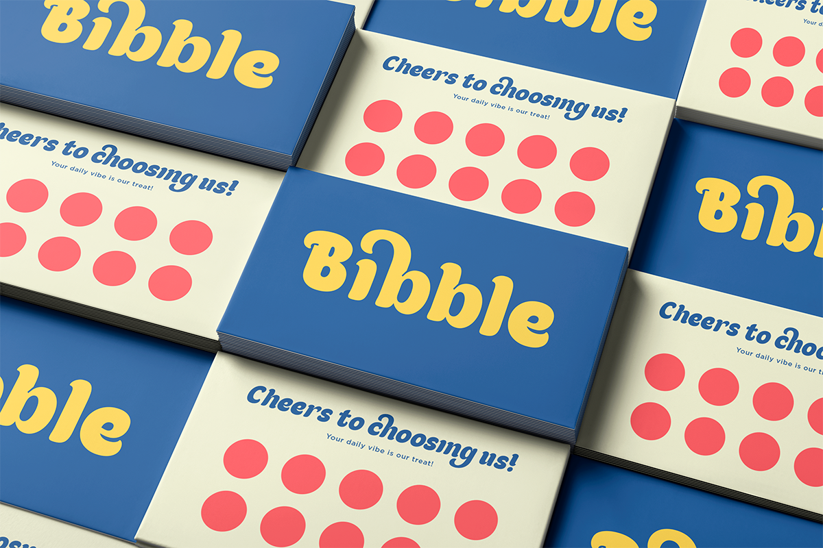 Stacked business cards for Bubble with yellow lettering on blue, cream sides with coral dots