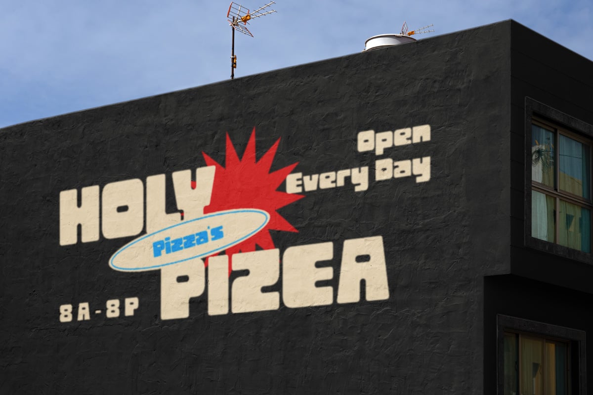 Vintage pizza shop sign on dark building with cream letters, red starburst, blue oval logo