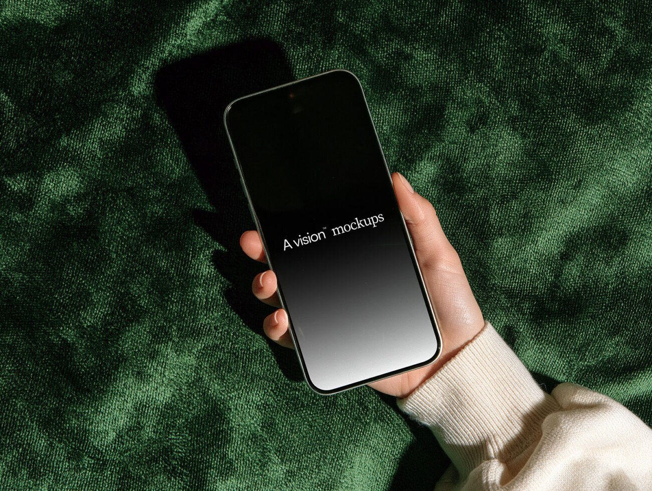 Hand holding smartphone with gradient screen on textured green fabric background