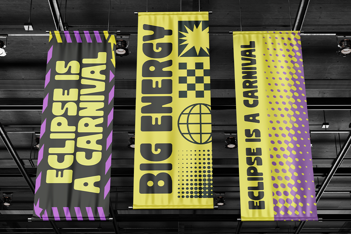 Three hanging banners with bold yellow type, purple accents, geometric patterns against dark ceiling