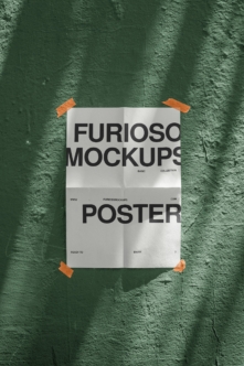 Folded poster mockup taped to textured green wall with orange tape corners