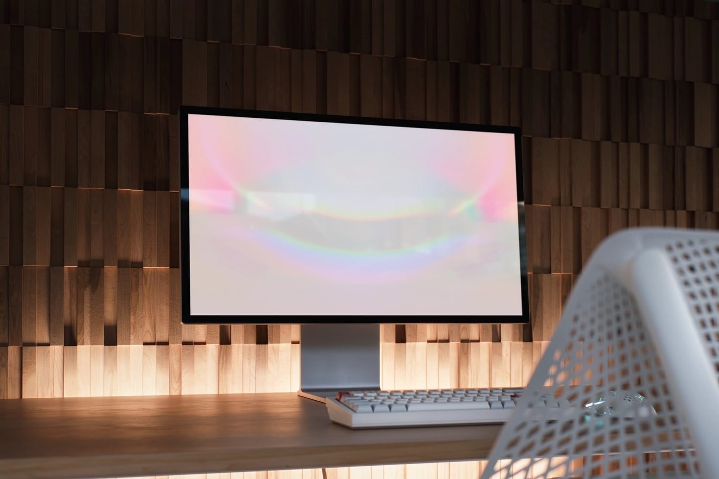 Monitor mockup on wooden desk with keyboard, soft pastel gradient on screen, warm wood slat wall backdrop