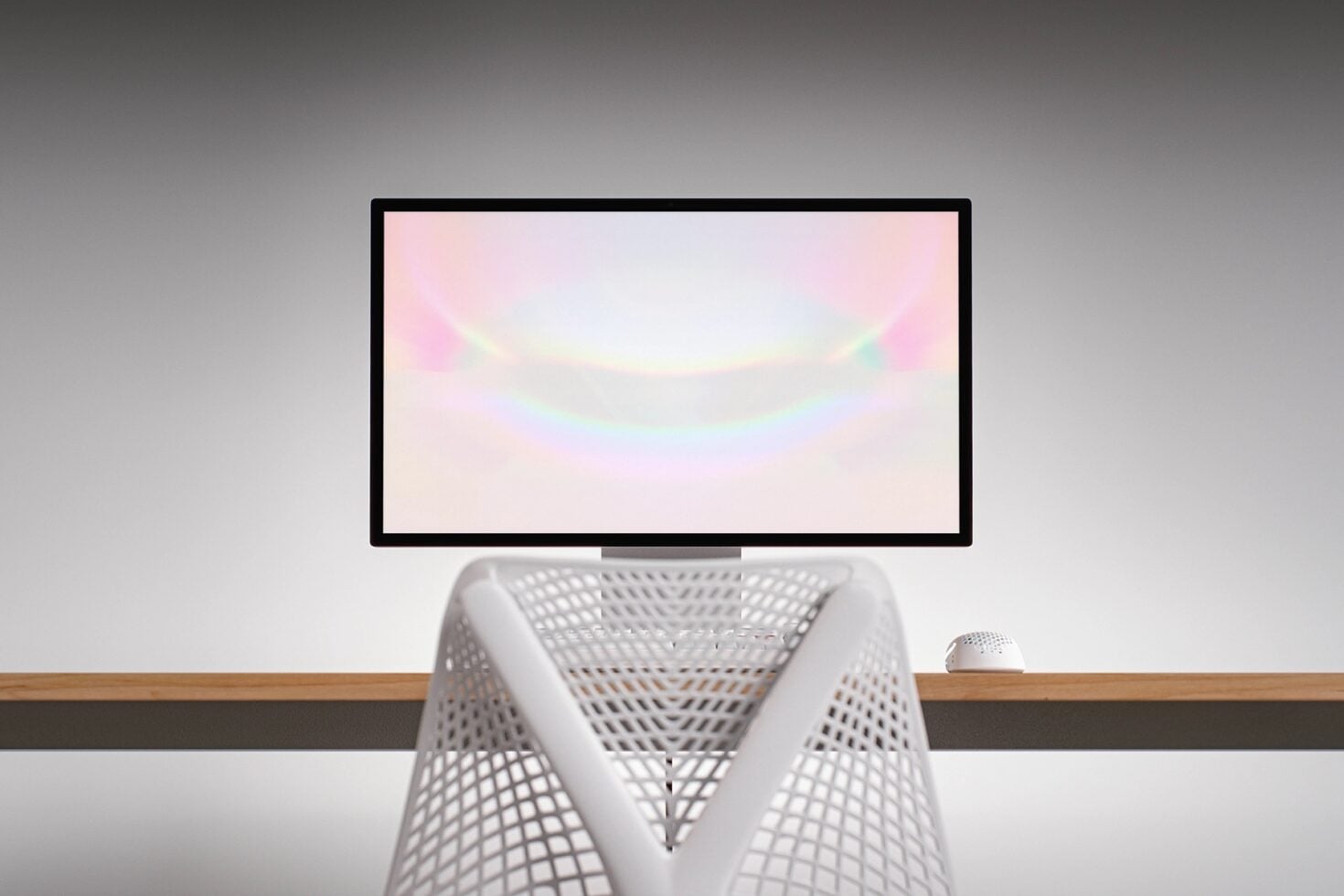 Desktop monitor mockup with pastel gradient display, white mesh chair, wireless mouse on wooden desk