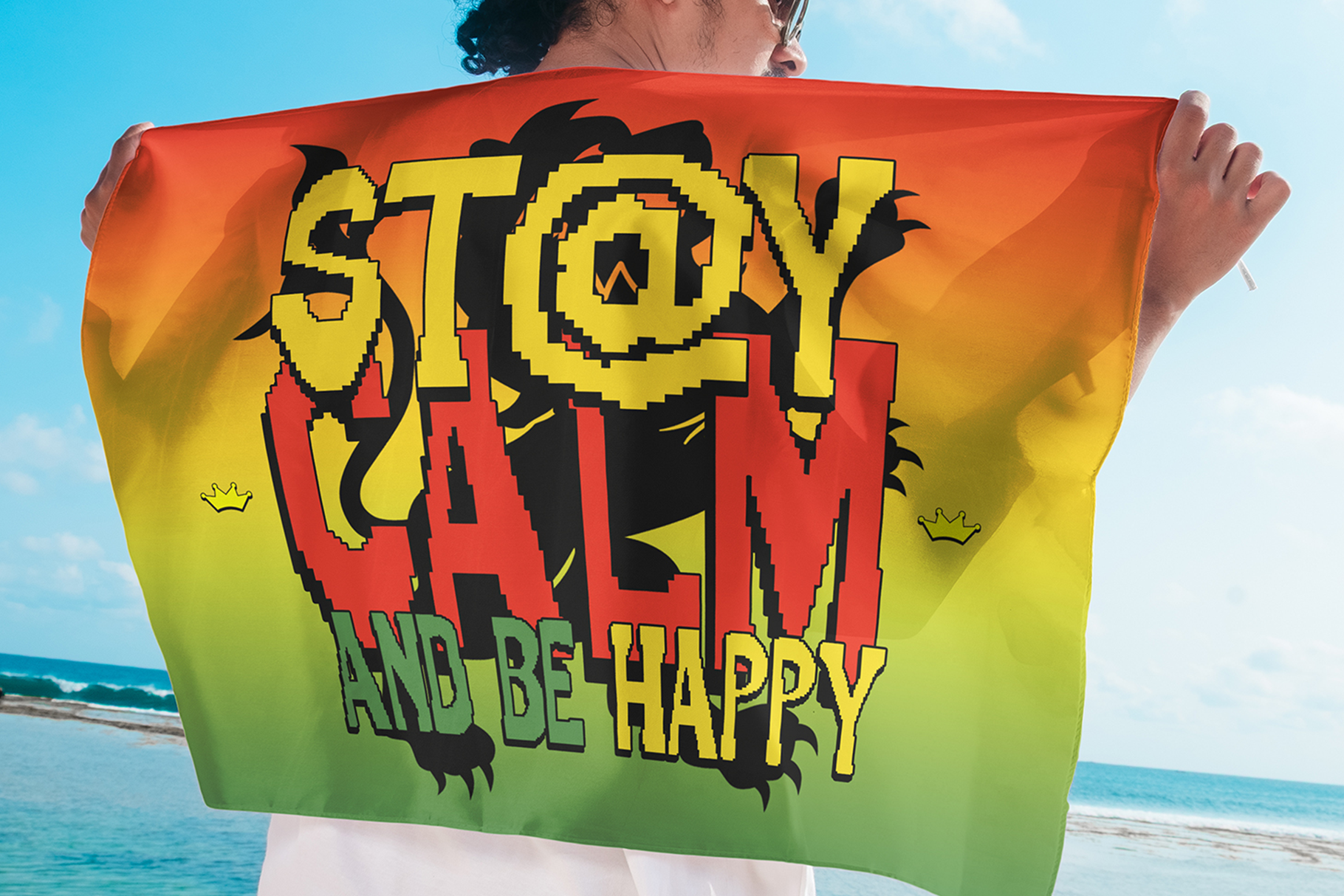 Colorful beach towel with pixel art monster design reading "STAY COOL BE HAPPY"