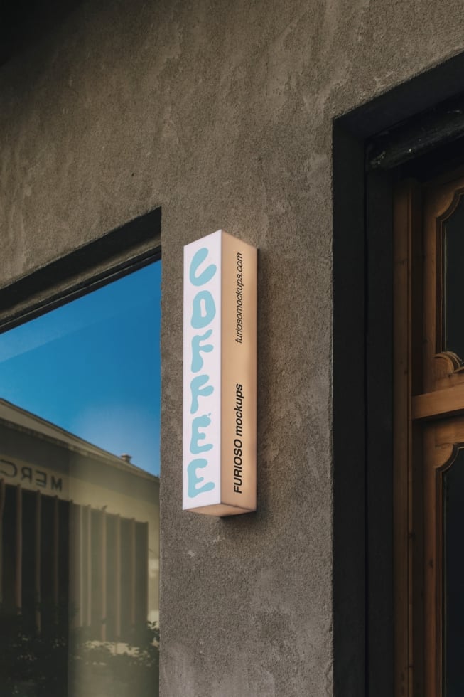 Vertical storefront sign mockup mounted on textured concrete wall between window display