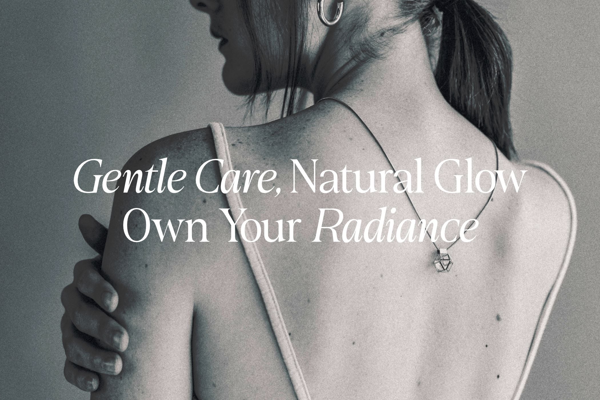 Woman from behind with bare shoulder, minimal jewelry, soft natural lighting with skincare messaging overlay