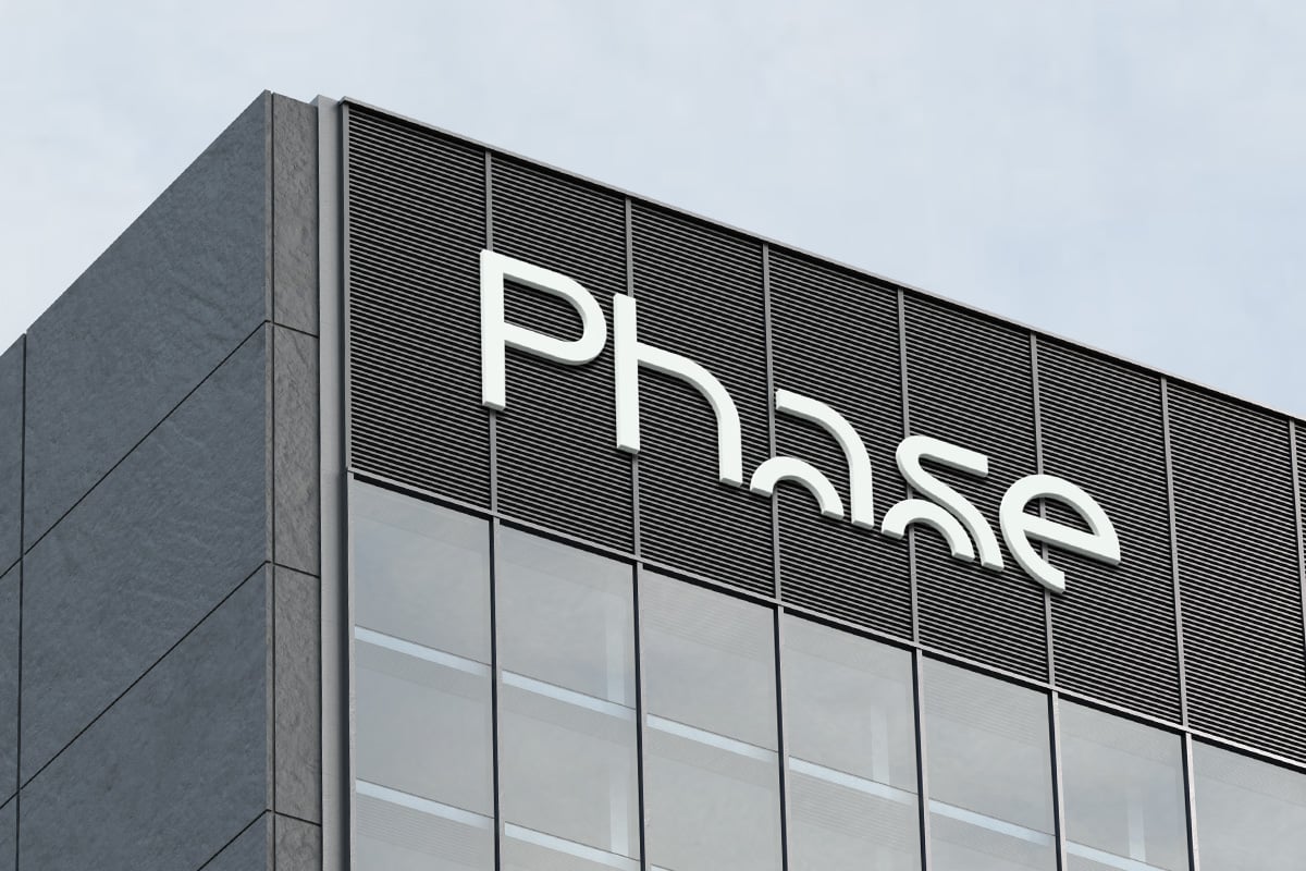 Modern building facade with white "phrase" lettering on horizontal louvered panel