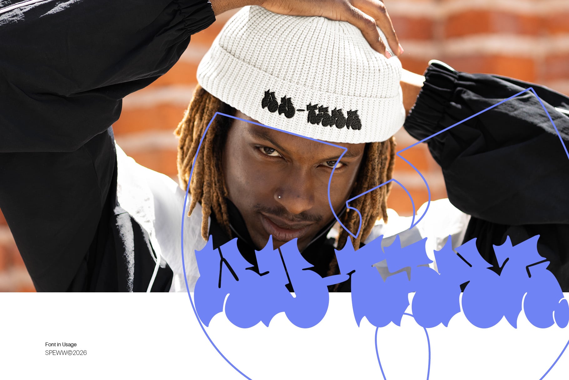 Guy in white beanie with custom text, blue graphic elements overlay, brick wall backdrop