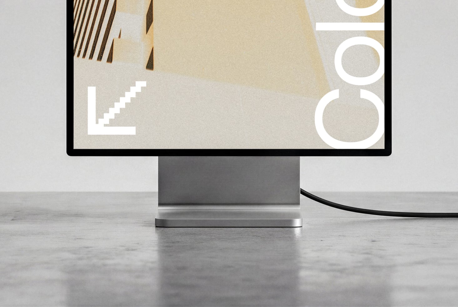 Desktop monitor mockup displaying minimal geometric design with beige tones, brushstrokes, plus icon on screen