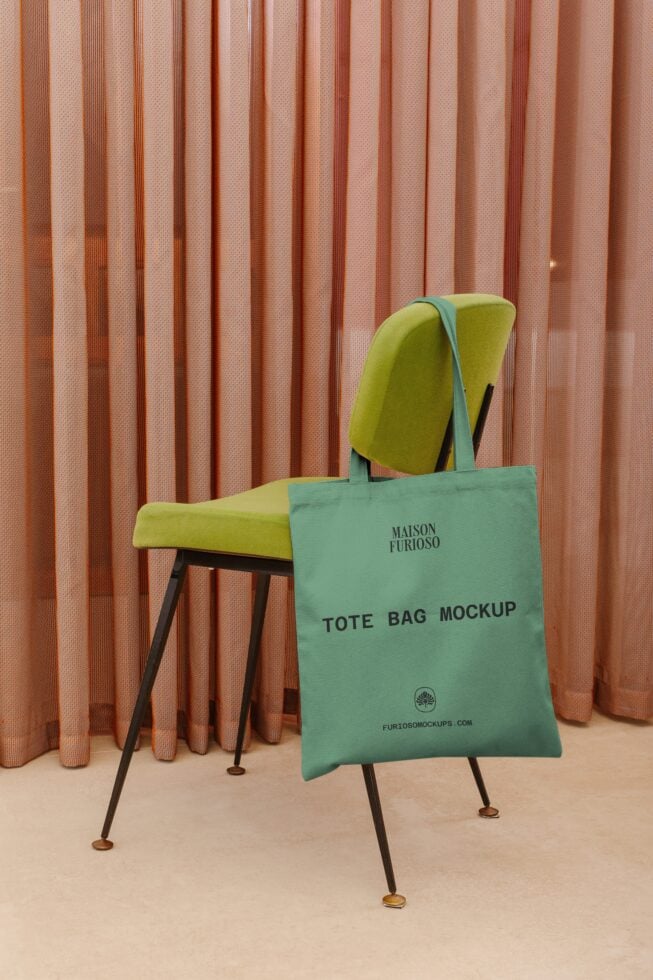 Sage tote bag mockup draped on lime green mid-century chair with terracotta curtains in background