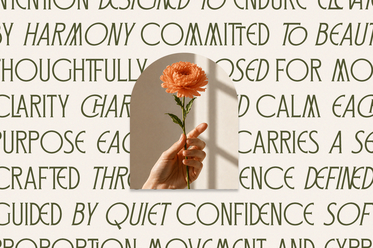 Hand holding coral peony flower with shadow on beige textured backdrop