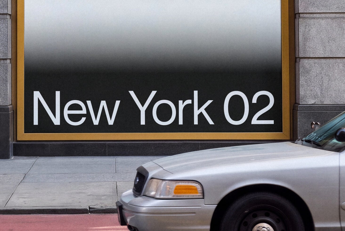 Silver cop car parked in front of storefront with New York 02 signage