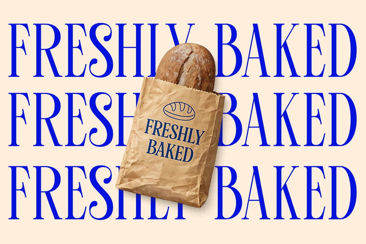 Sourdough loaf in kraft paper bag with freshly baked stamp on cream background
