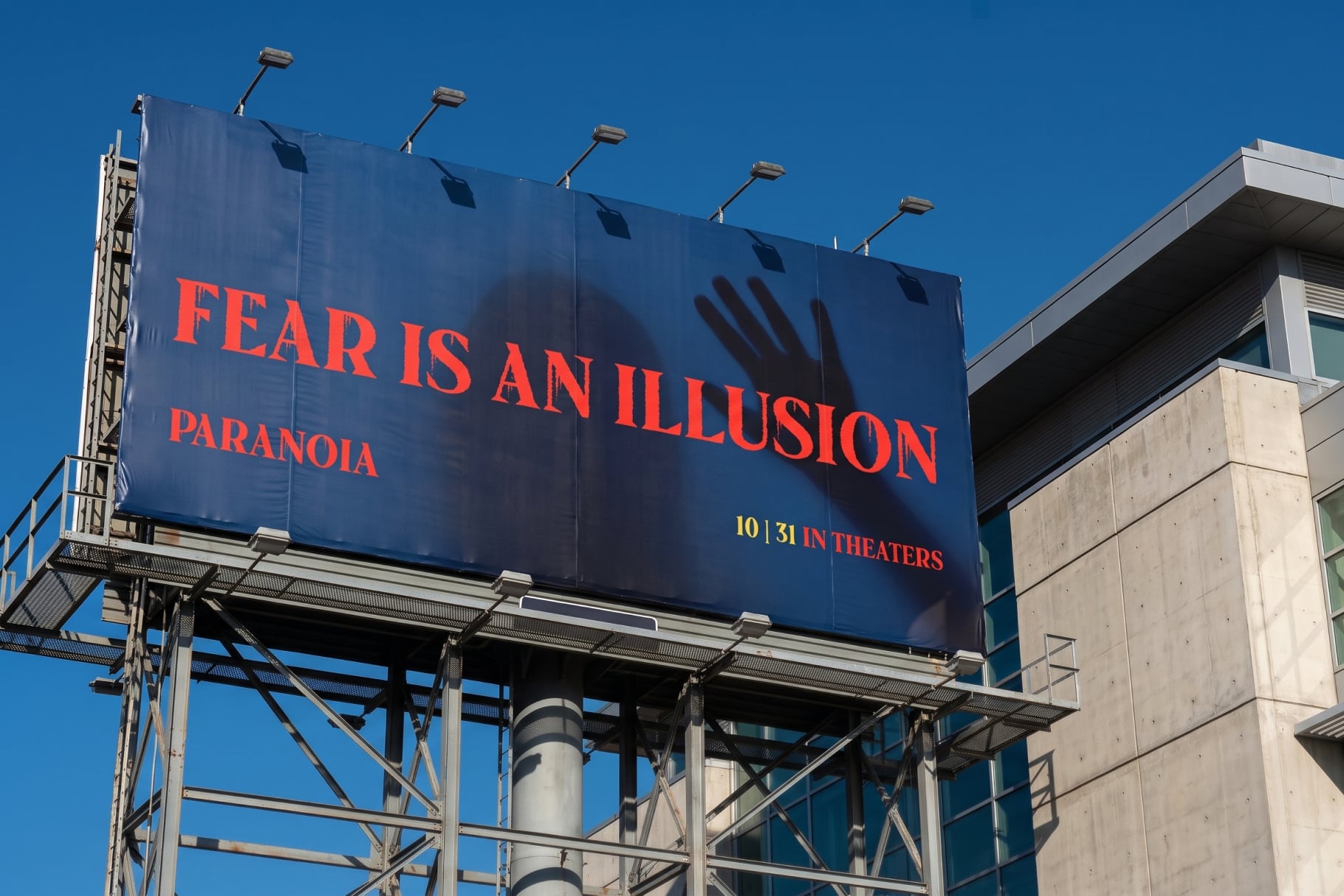 Movie billboard mockup with red text on deep blue, clear sky backdrop, theater release date visible
